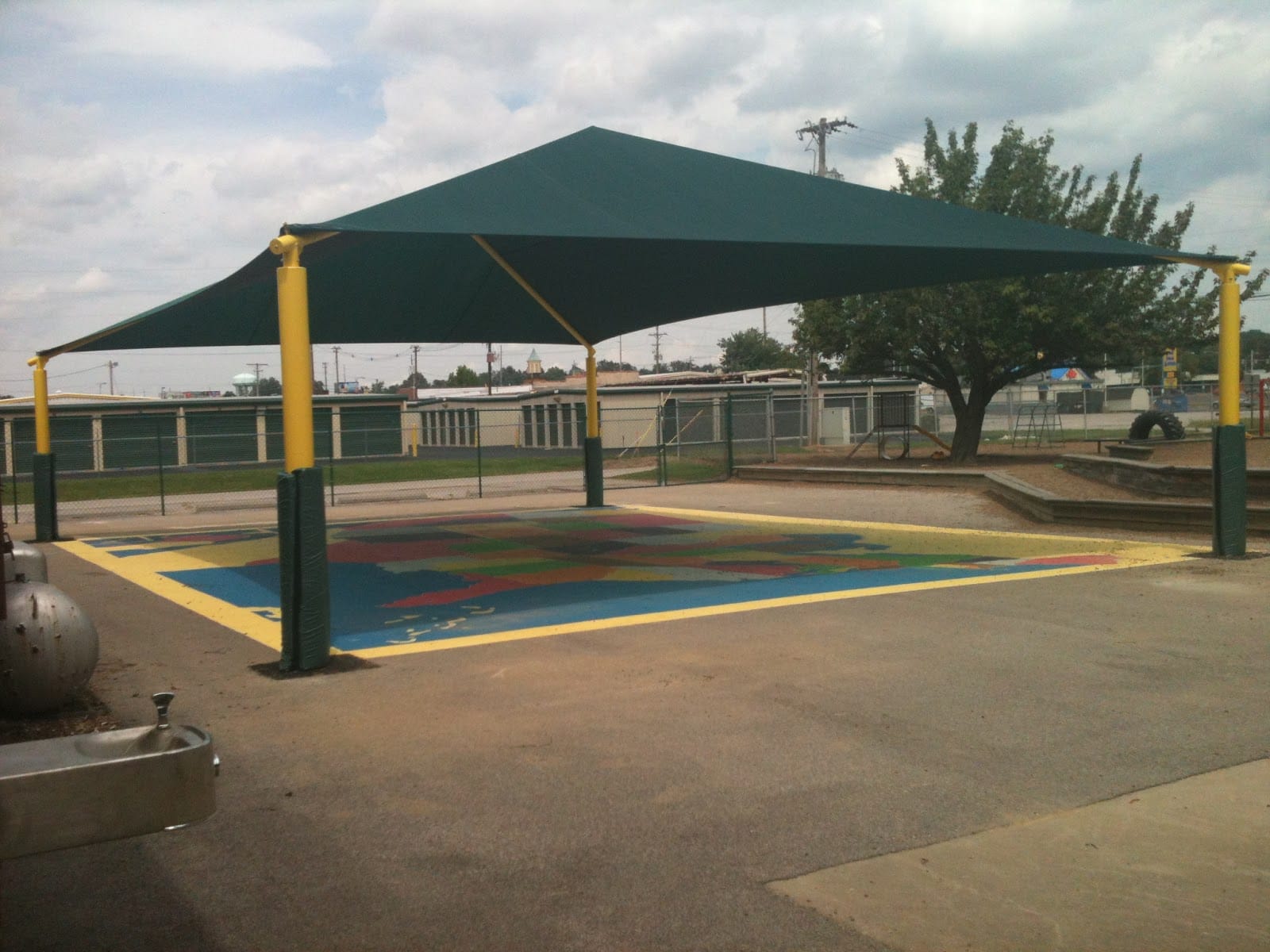 Large playground shade canopy structure over a colorful map of the United States